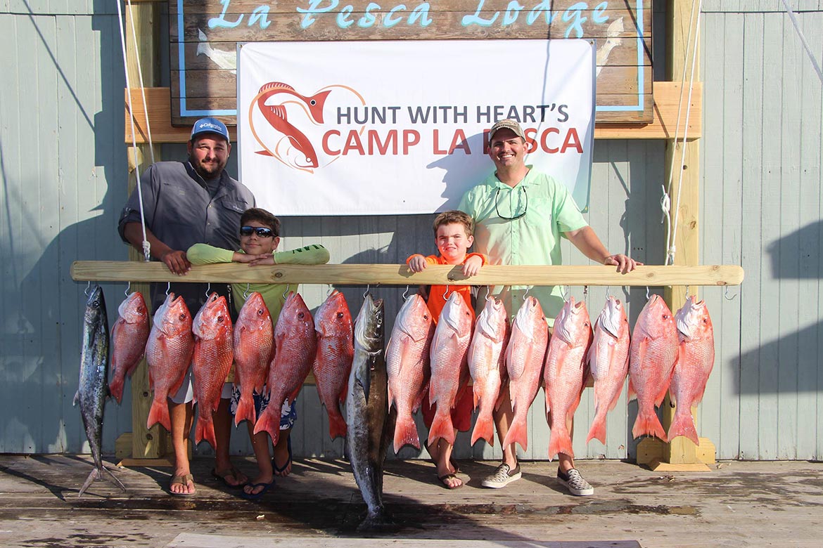Group of people in displaying their recent hunting kills