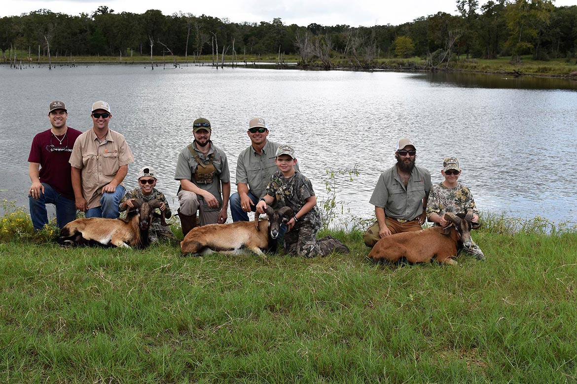 Group of people in displaying their recent hunting kills