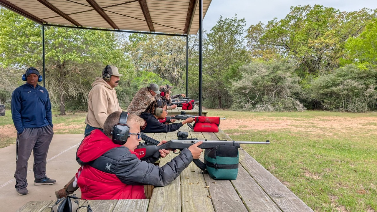 Boys on top of a car looking through binoculars